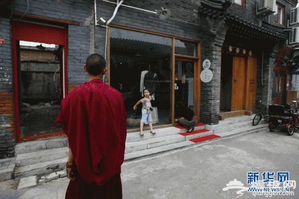一名小女孩儿正在和一名喇嘛打招呼