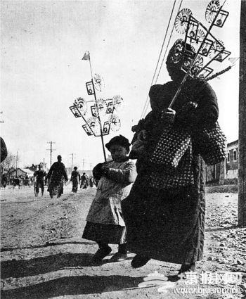 图一:上世纪30年代末40年代初，北京人庙会买风车。