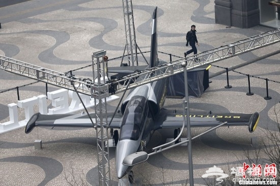 3月6日，一架1:1比例的战斗机模型停放在北京王府井街头，引来不少民众驻足观赏。据悉，这架战斗机模型为某手表商家为庆祝开业而布置的展品。中新社发 富田 摄