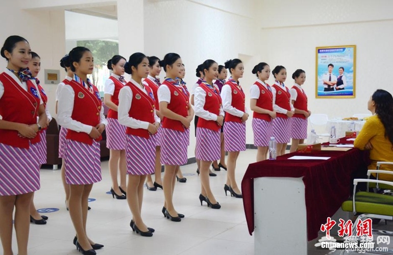 图为面试官正在一一对面试女生进行现场考察。东明 摄