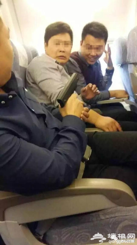 三男子在飞机上持“枪”拍照[墙根网]