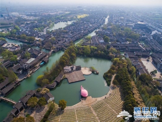 3月27日,粉红色的“浮鱼”首次亮相水乡乌镇西栅景区水剧场。这件作品是“大黄鸭之父”弗洛伦泰因·霍夫曼根据乌镇西栅景区内“水剧场”的空间环境而创作,也是即将开幕的“乌镇国际当代艺术邀请展”的重要参展作品之一。 3月28日至6月26日,“乌镇国际当代艺术邀请展”将在浙江省桐乡市乌镇景区内举行,展览汇集来自15个国家和地区的40位(组)艺术家的55组(套)130件作品,包括绘画、雕塑、摄影、装置、影像、动画、行为、声音等多媒介方式。新华社记者 徐昱 摄