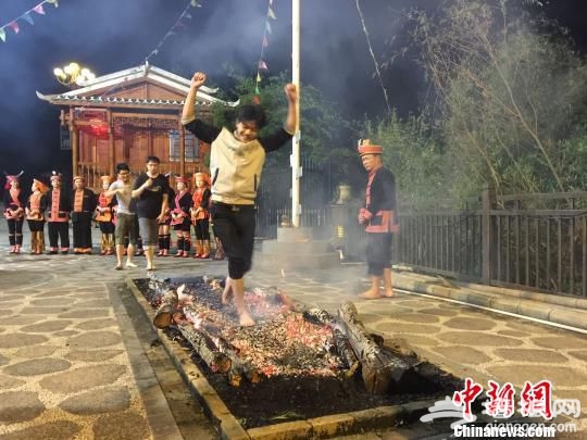 广西金秀瑶族自治县举办“中国金秀·2016年圣堂山杜鹃花旅游节”,图为游客体验民俗绝技“下火海”。 廖敏佳 摄 广西金秀瑶族自治县举办“中国金秀·2016年圣堂山杜鹃花旅游节”,图为游客体验民俗绝技“下火海”。 廖敏佳 摄