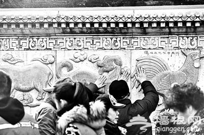 北京白云观生肖雕像被摸得发亮 游客排几十米长队