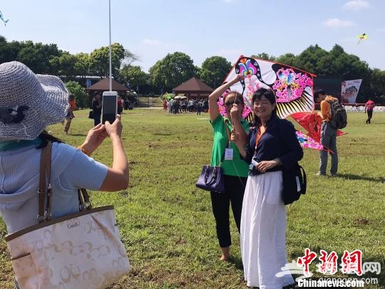 风筝爱好者与燕子风筝合影。　王子涛 摄